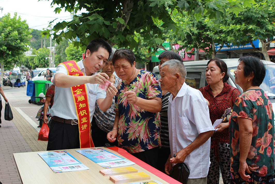多年来，为构建和谐稳定的金融消费环境，建行致力做好金融权益的守护者、排头兵，主动“走出去”，走进农村、社区、校园、企业、商圈，把金融惠民利民举措和金融知识送到基层一线。图为建行黄岩支行宣传员在街边向民众展示“反假币”辨别技巧。.jpg